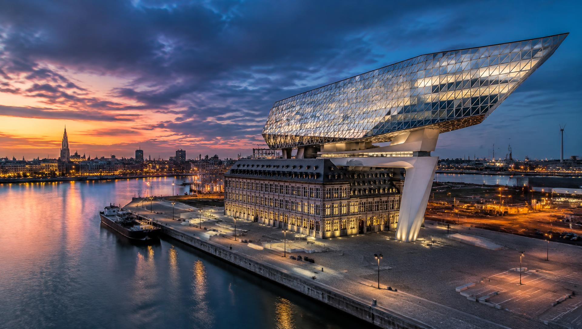 Cinematische dronefoto van moderne glasarchitectuur in Antwerpen tijdens blue hour